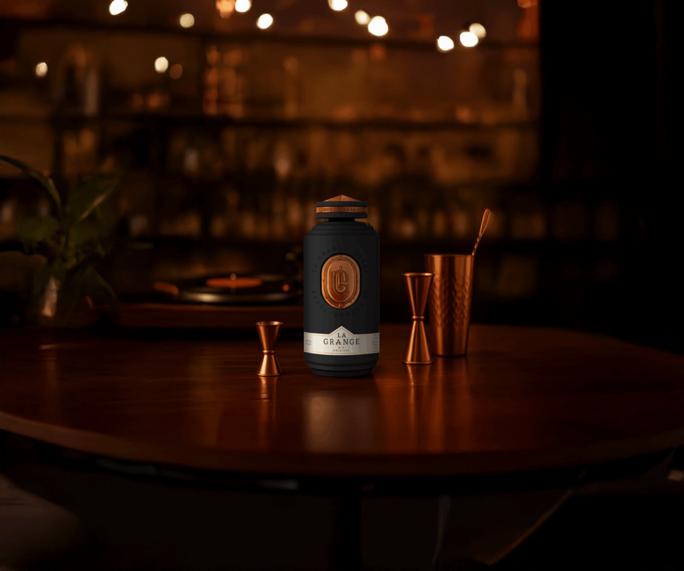 La Grange Original gin bottle on a candlelit bar table beside copper jiggers and a cocktail shaker