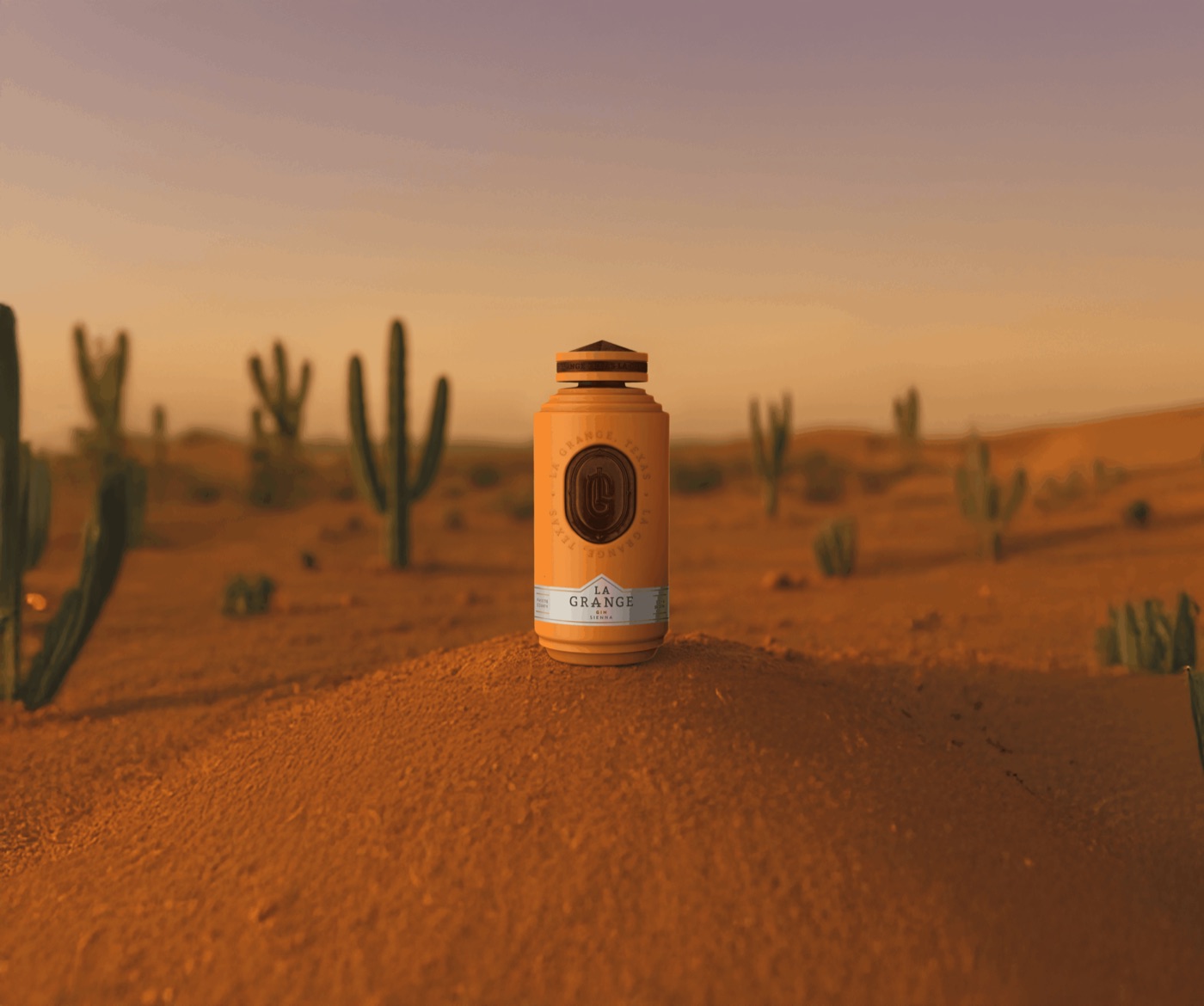 La Grange Sienna gin bottle standing on red sand among cacti at dusk